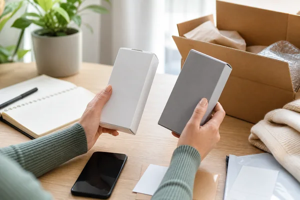 A shopper carefully comparing two boxed products and their condition